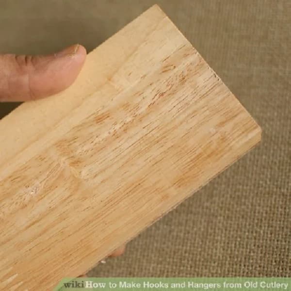 main tenant une planche de bois