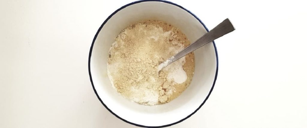 Mug remplit avec de la farine et du lait, avec une petite cuillère.