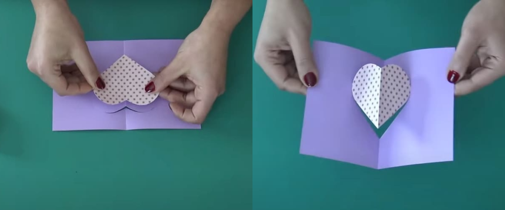 Mains collant un cœur avec motifs sur sur une carte pop-up violette