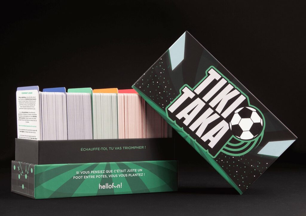 Boîte du jeu Tiki Taka ouverte avec les paquets de cartes rangés par période