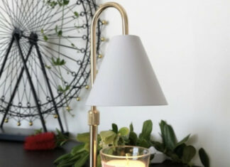Comment fonctionne une lampe chauffe-bougie ? Lampe chauffe-bougie Candelia avec abat-jour blanc au-dessus d'une bougie parfumée en verre